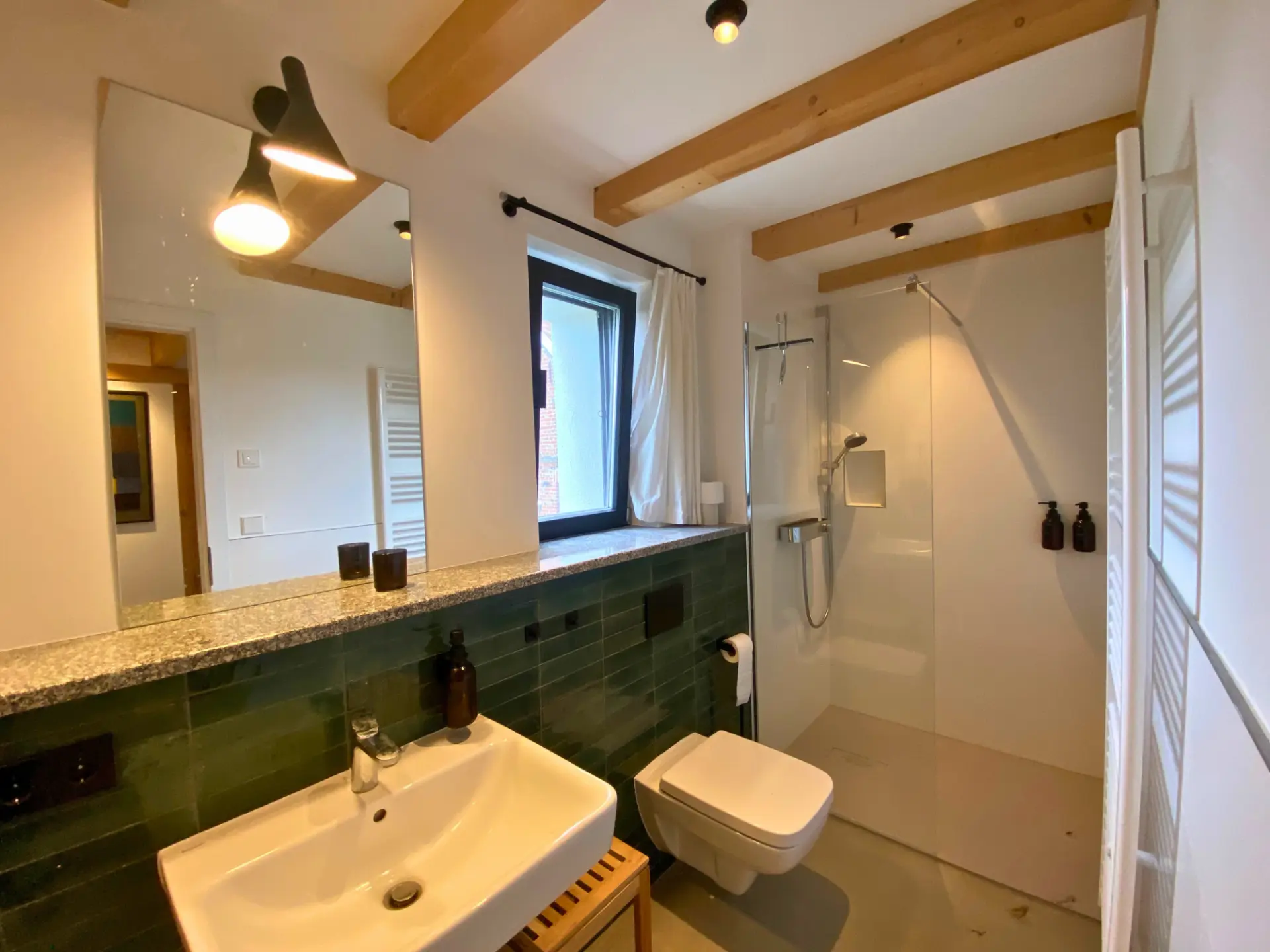 Zweites Duschbad mit Waschtisch, WC und Glasdusche unter den Deckenbalken