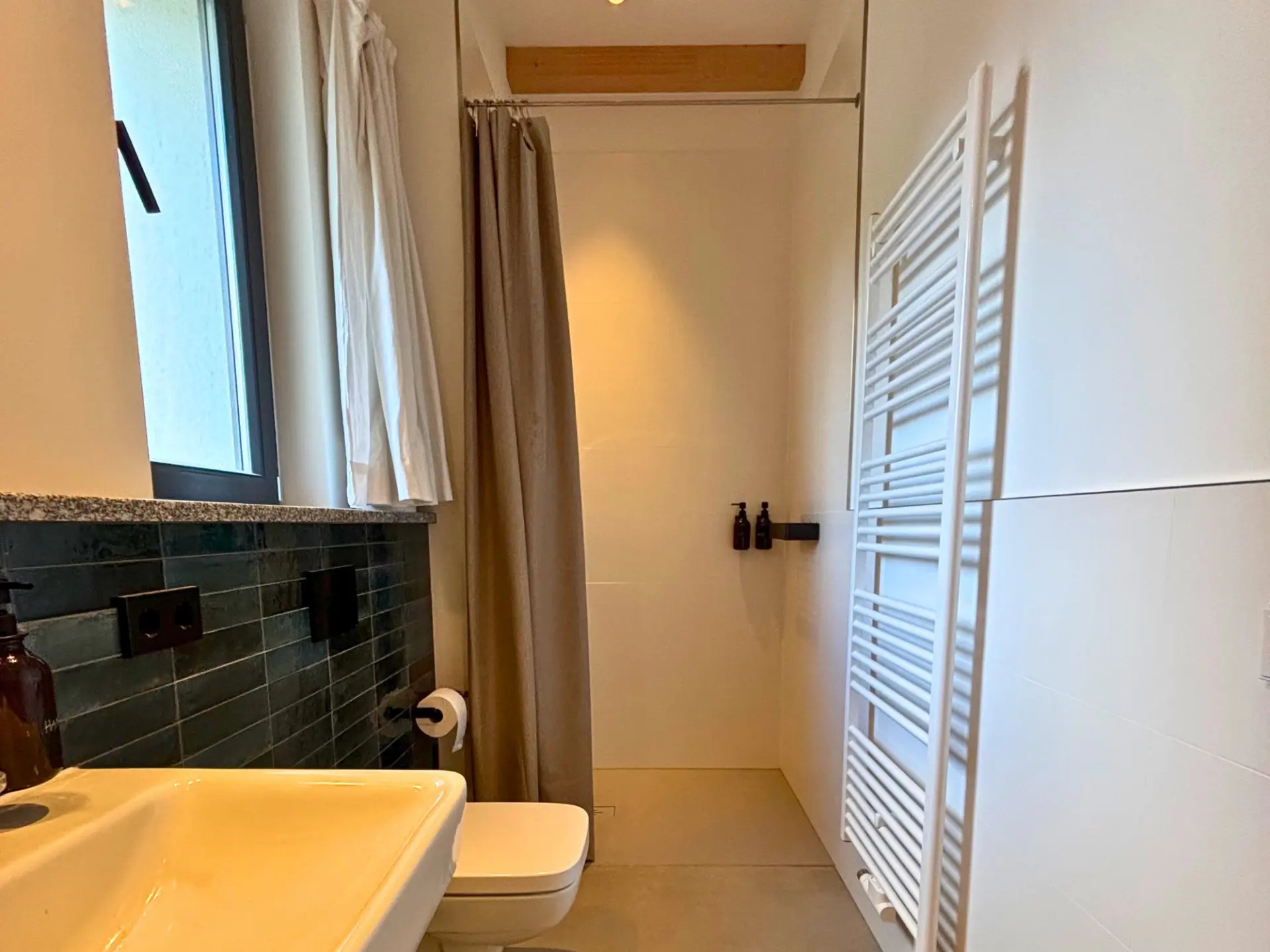 Bodengleiche Dusche mit beigem Vorhang und Hänge-WC im Duschbad