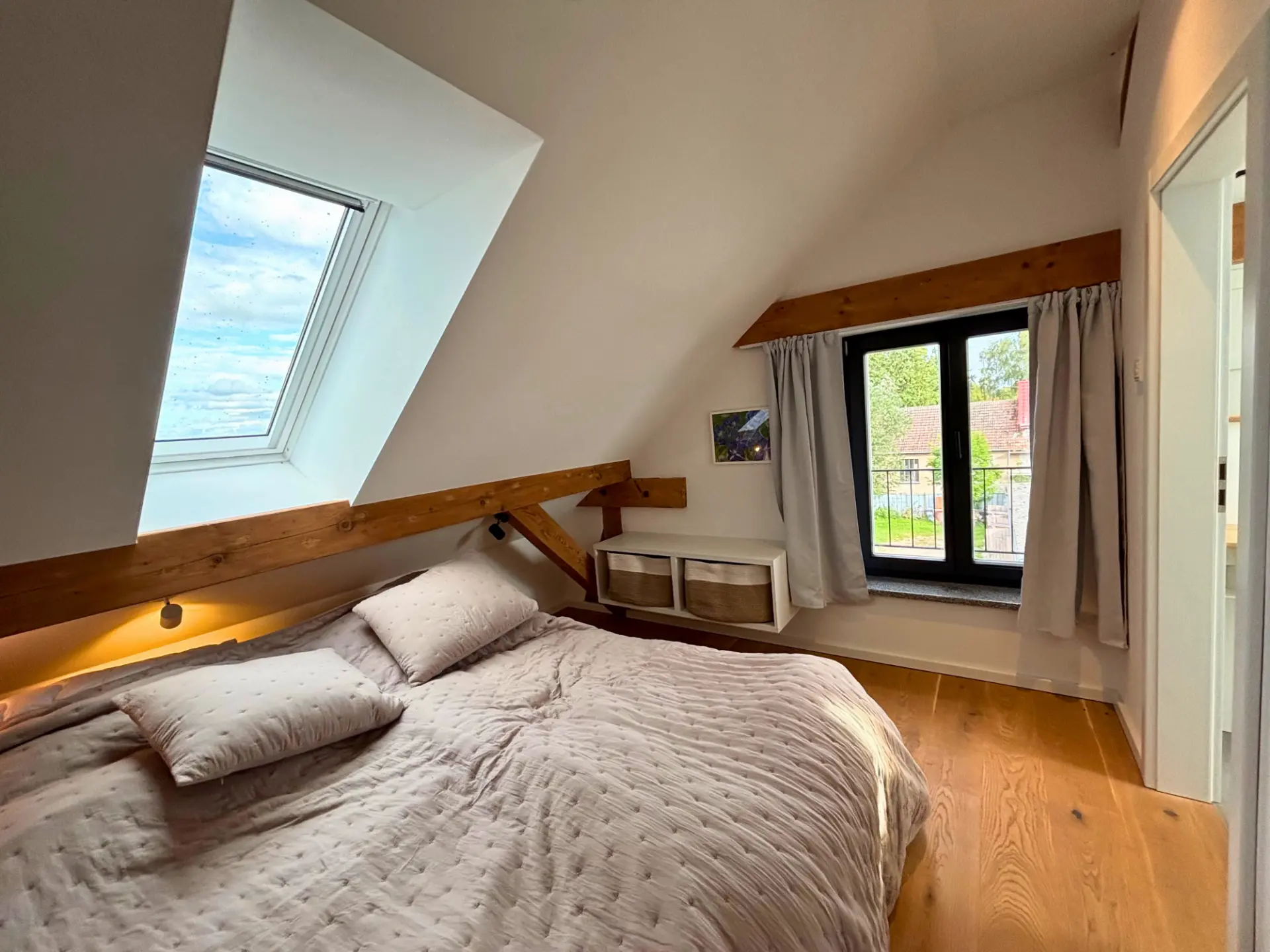 Schlafzimmer unterm Dach: Doppelbett mit beleuchtetem Kopfteil unter der Dachschräge